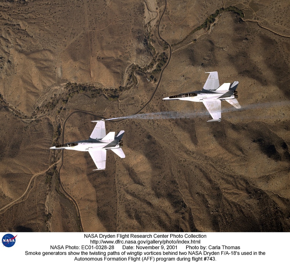 Smoke generators show the twisting paths of wingtip vortices behind two NASA Dryden F/A-18's used in