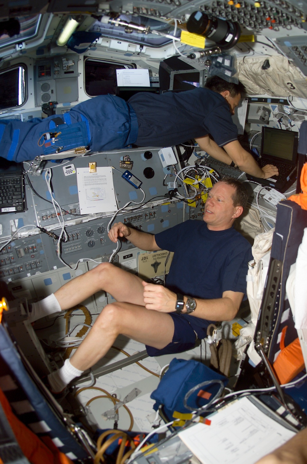 Brown exercises as Ramon types on a laptop on Columbia's AFD during STS-107
