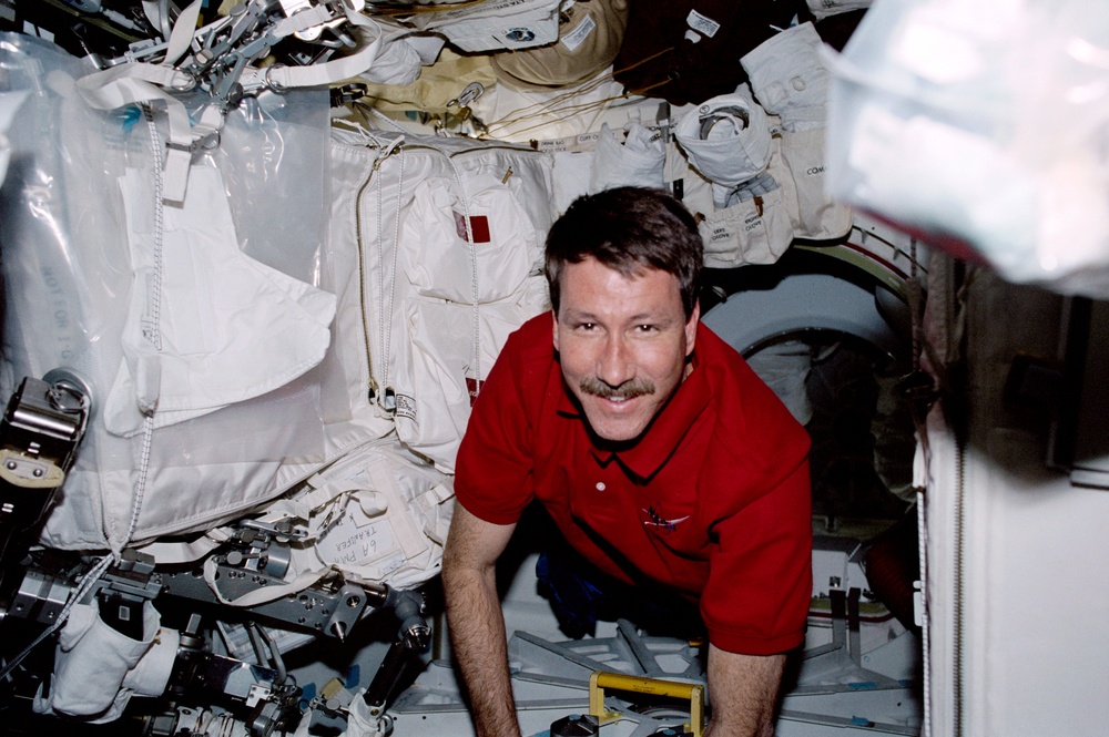 Commander Rominger secures the airlock hatch on Endeavour's middeck during STS-100