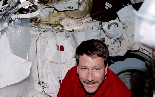 Commander Rominger secures the airlock hatch on Endeavour's middeck during STS-100