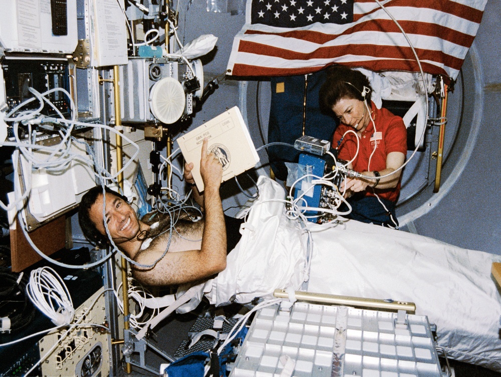 Crewmembers in the spacelab with the Lower Body Negative Pressure Study.