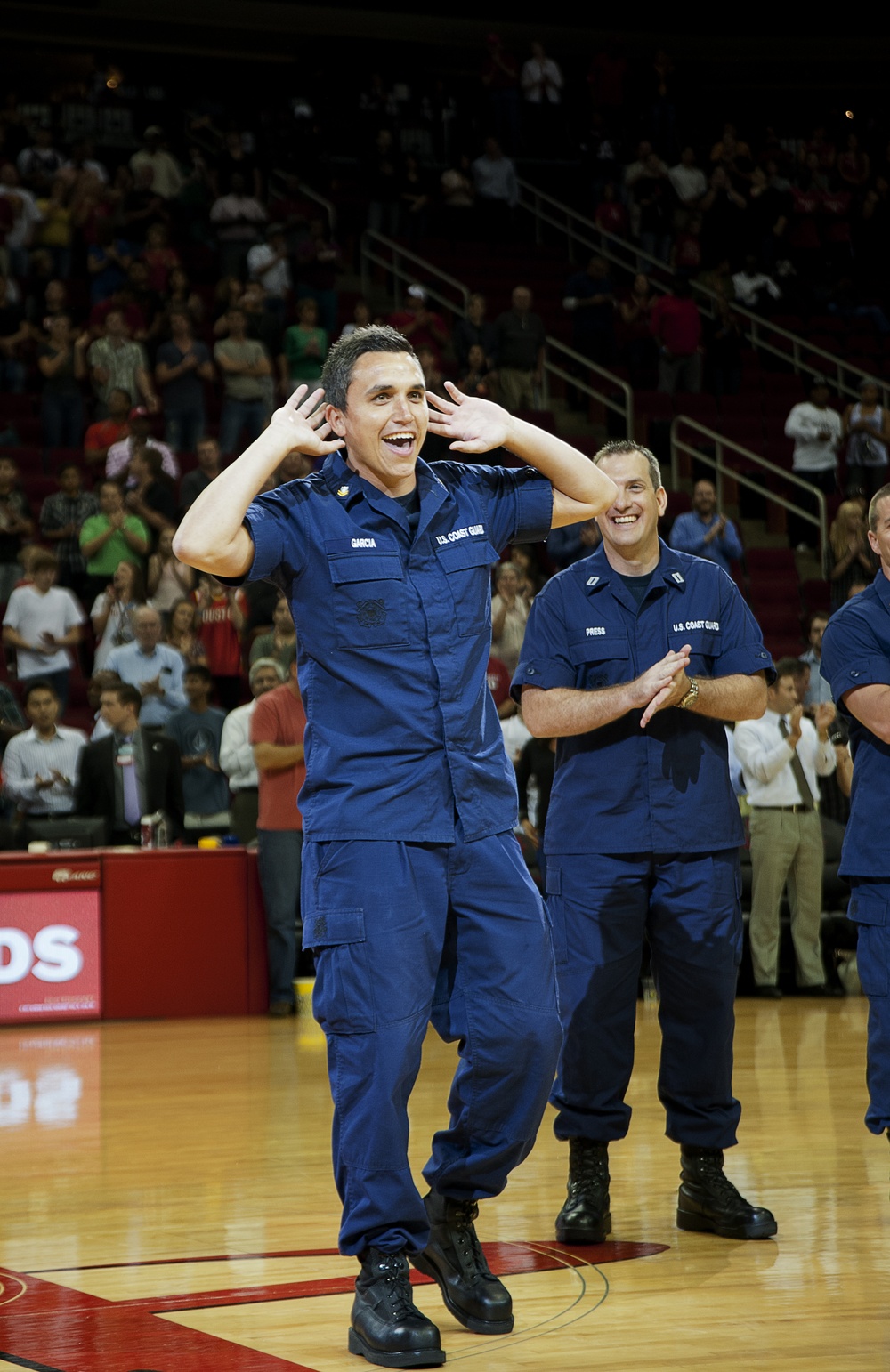 Petty Officer 2nd Class Andrew Garcia eggs on a crowd at a Houston Rockets halftime show