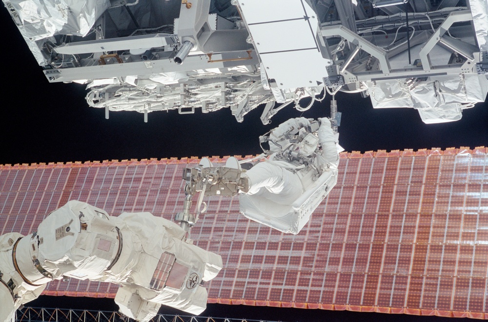 MS Walheim works on a Forward Avionics Umbilical during the first EVA of STS-110