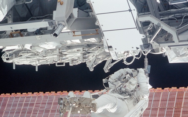 MS Walheim works on a Forward Avionics Umbilical during the first EVA of STS-110
