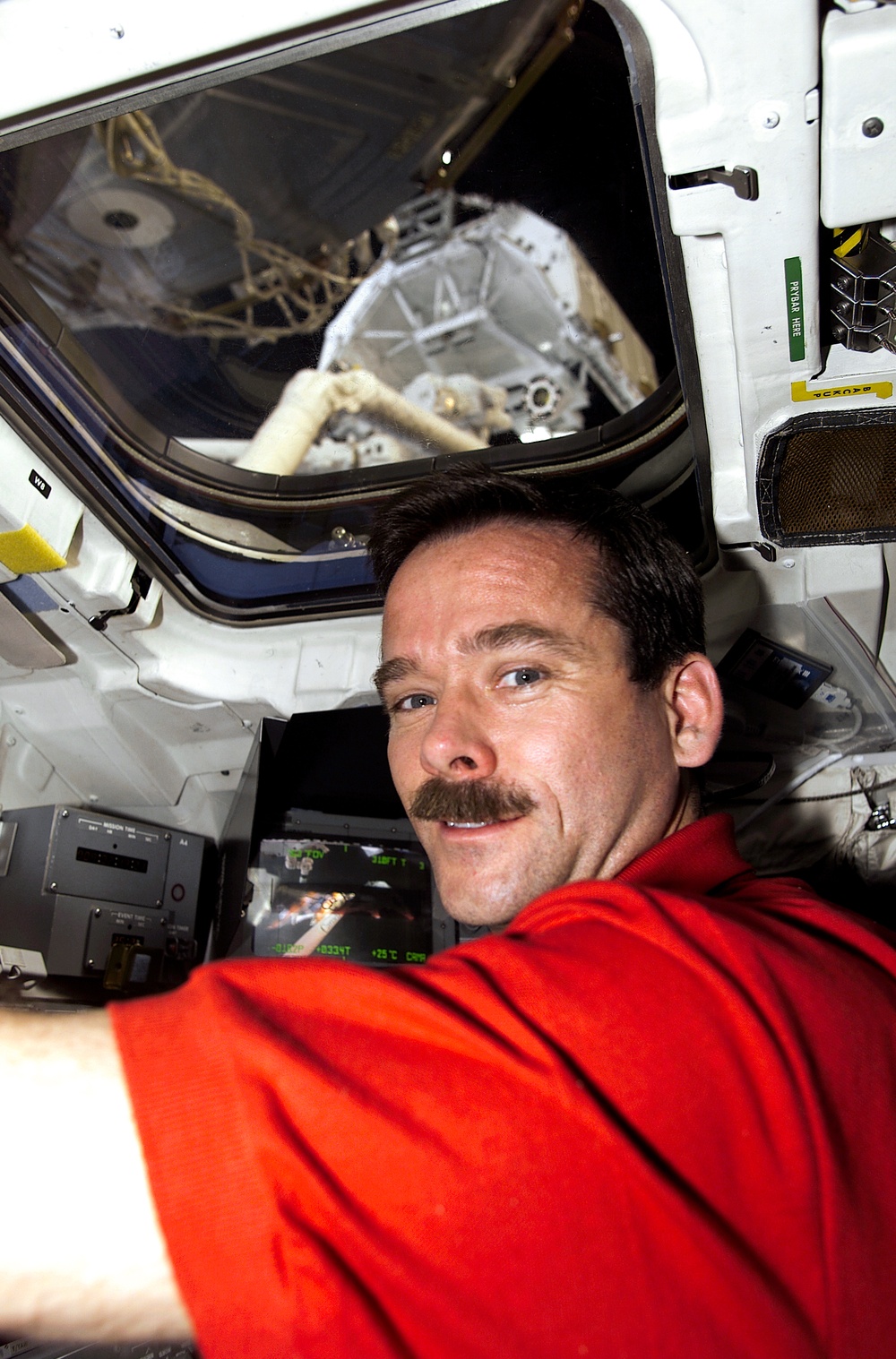 MS Hadfield works at the RMS controls on the flight deck of Endeavour during RMS handshake