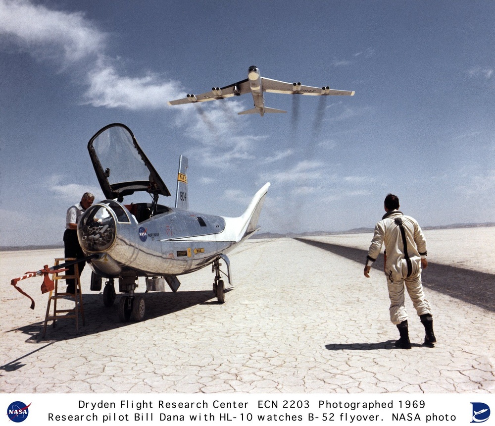 HL-10 on lakebed with B-52 flyby