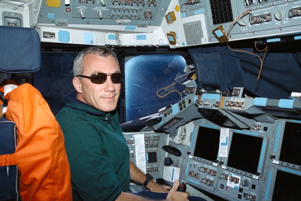 Wilcutt poses wearing sunglasses at the commander's workstation