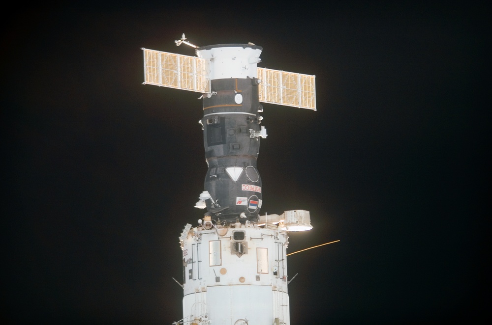 View of a Progress vehicle docked to the SM as the orbiter Discovery moves in for docking during STS-121
