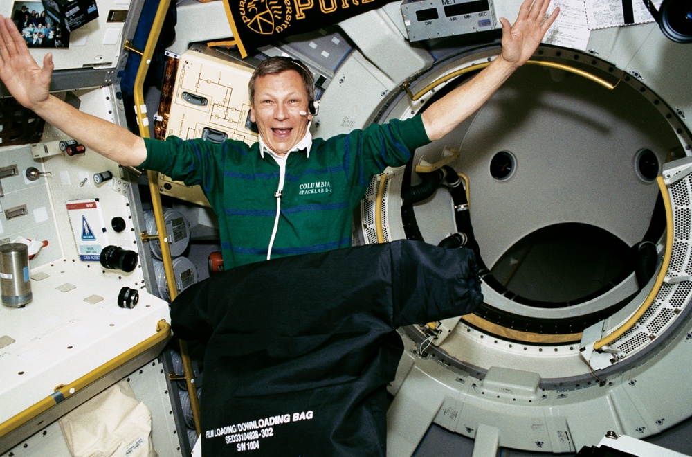 Crewmember in the D-2 Spacelab loading/downloading film in the camera bag.