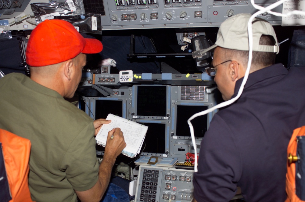 Sturckow and Archambault look over checklists on the FD of STS-117 Space Shuttle Atlantis