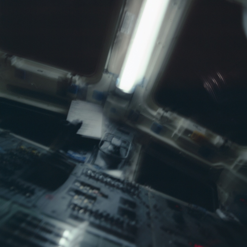 A dark image of the aft flight deck of Endeavour taken during the STS-100 mission