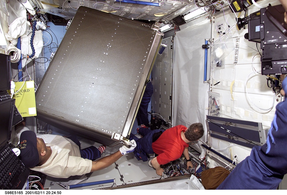 STS-98 crewmember move rack into U.S. Laboratory / Destiny module