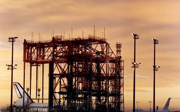 STS-92 - Orbiter in Mate-Demate Device (MDD) at sunrise with Shuttle Carrier Aircraft (SCA) in backg
