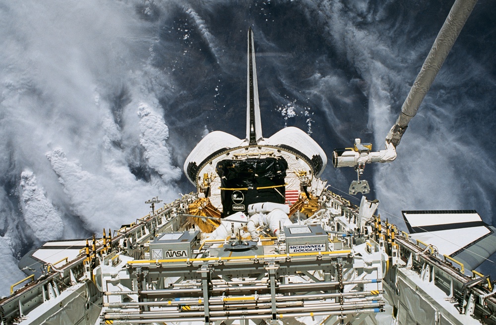Two crewmember EVA in the payload bay to set up the INTELSAT capture station.