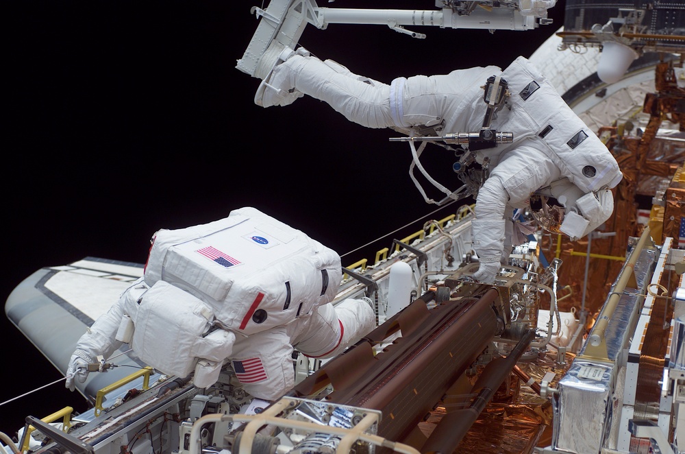 STS-109 MS Grunsfeld and Linnehan stow old solar array from payload bay