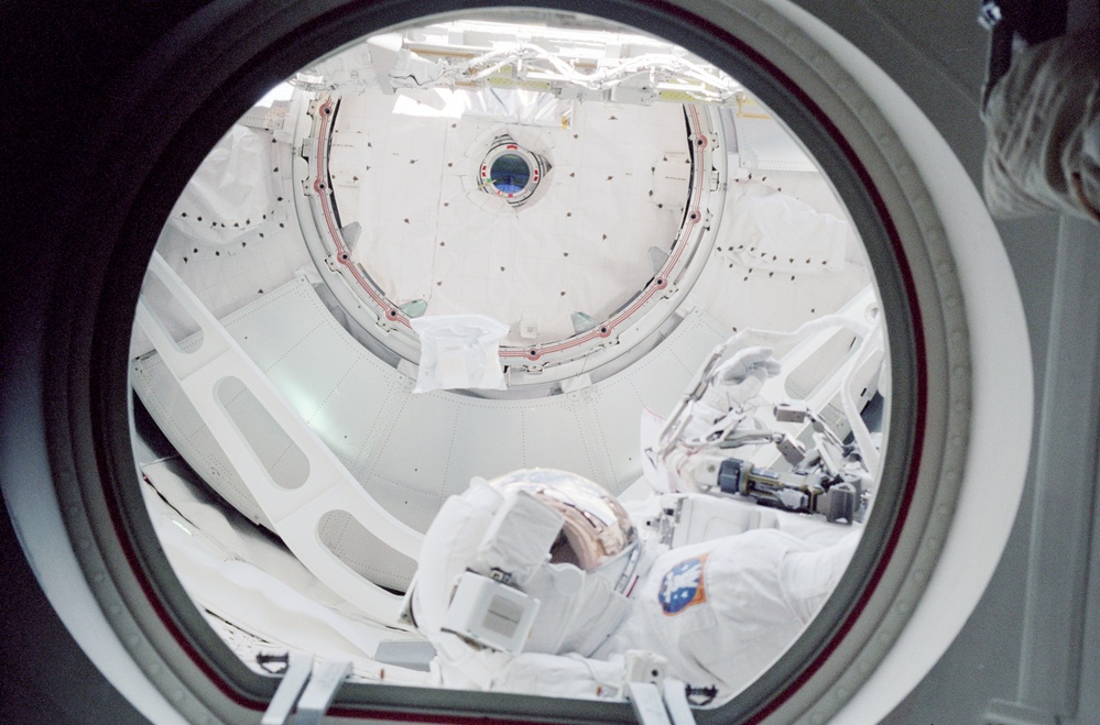 EMU suited Helms exits the hatch to begin an EVA
