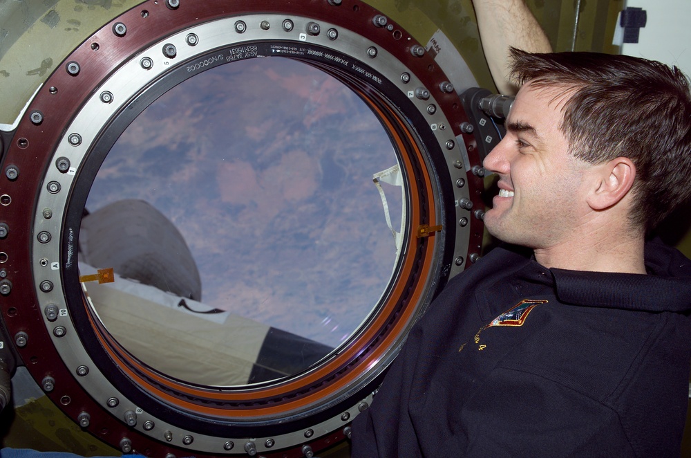 Walheim looks out the nadir window of Destiny during STS-110's visit to the ISS