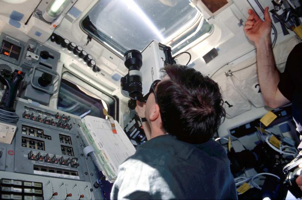 Walheim uses the laser rangefinder on the aft flight deck during the final flyaround of STS-110