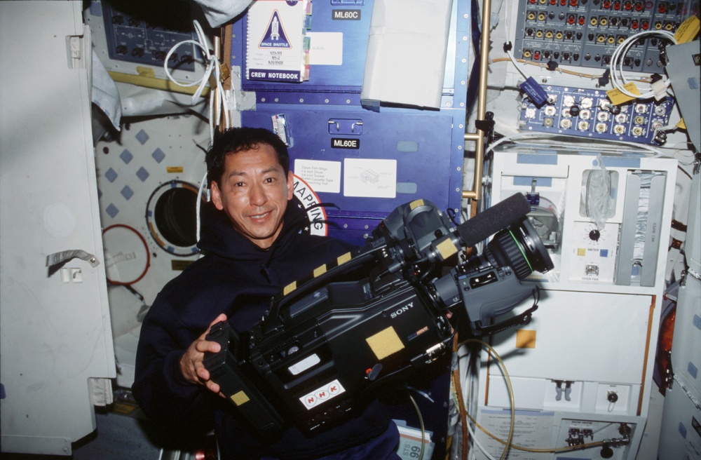 STS-99 MS Mohri poses with an HD camera on OV-105's middeck
