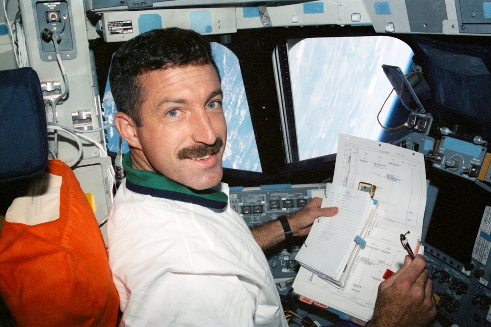 MS Burbank reads a checklist on the flight deck during STS-106