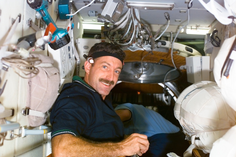 MS Burbank works with stowage bags on Zvezda during STS-106