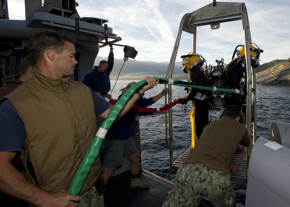 US Navy Divers, alongside the Joint POW/MIA Accounting Command, search for an unaccounted-for service member who went missing during World War II