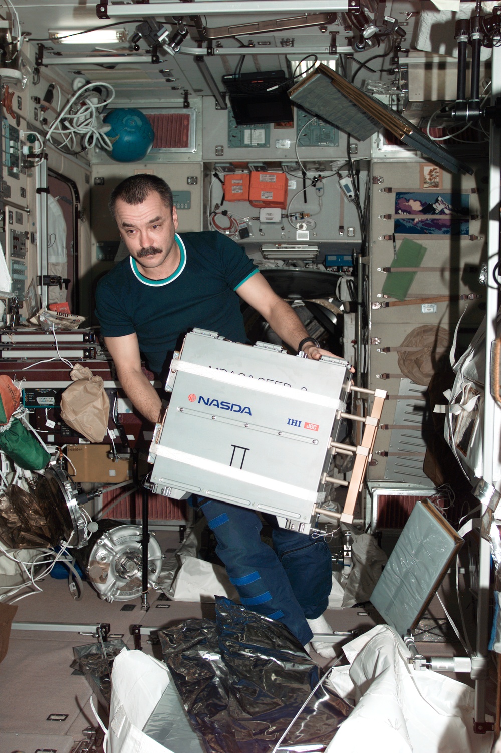 Tyurin handles a NASDA exposure experiment case in Zvezda during Expedition Three