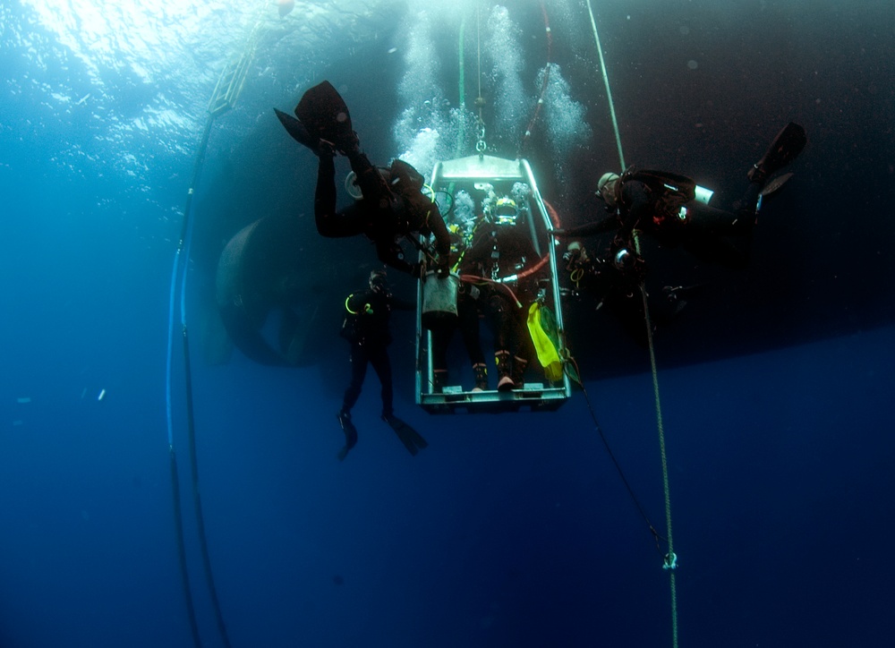 US Navy divers, alongside the Joint POW/MIA Accounting Command, search for an unaccounted-for service member who went missing during World War II