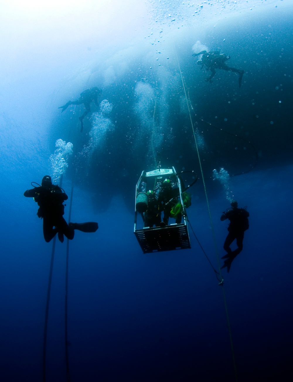 US Navy divers, alongside the Joint POW/MIA Accounting Command, search for an unaccounted-for service member who went missing during World War II