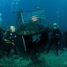 US Navy divers, alongside the Joint POW/MIA Accounting Command, search for an unaccounted-for service member who went missing during World War II