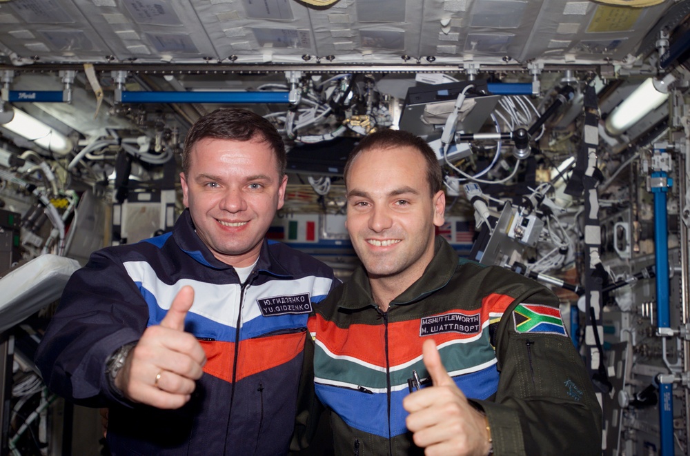 Gidzenko and Shuttleworth thumbs up photo in U.S. Lab during Expedition Four