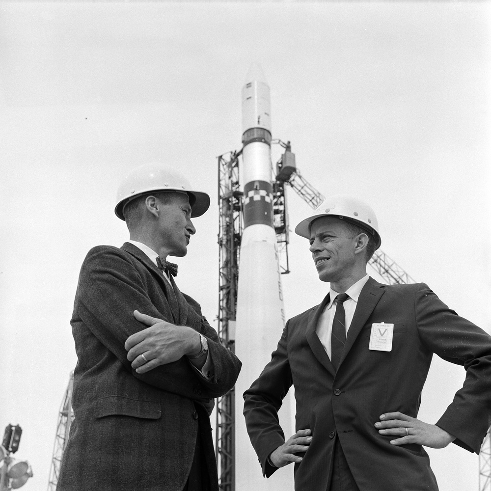 RICHARD DILLON PROJECT ENGINEER FOR AGENA POLAR ORBITING GEOPHYSICAL OBSERVATORY POGO LAUNCH AND DR R GRAY OF NASA KENNEDY SPACE CENTER AT WTR WITH VEHICLE IN BACKGROUND