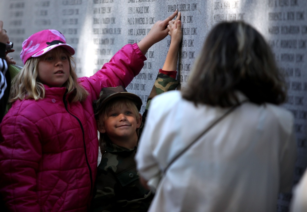 Children point to fallen service member's name