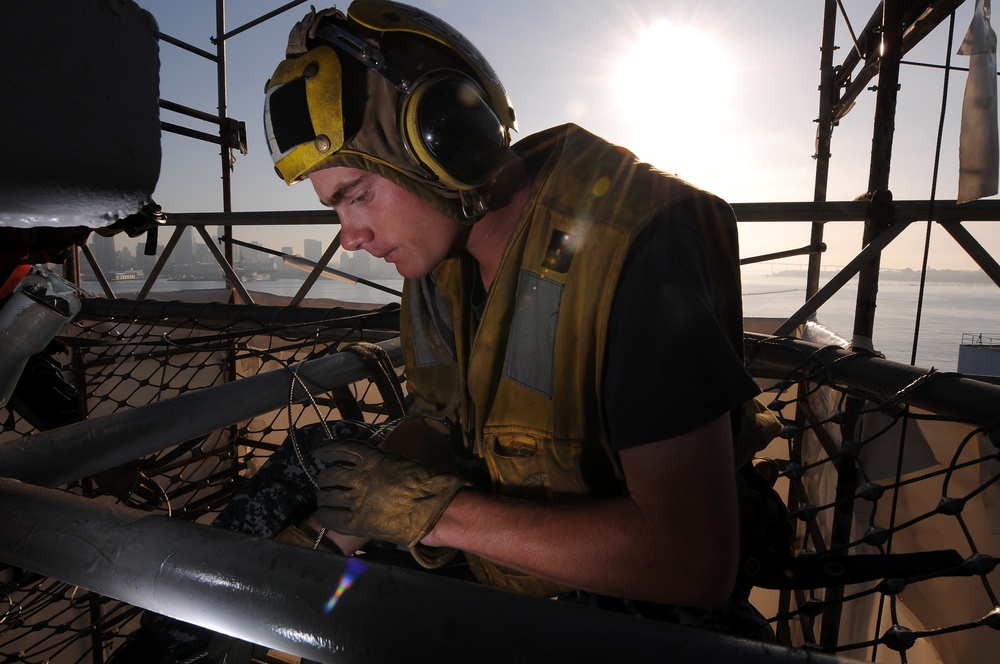 USS Carl Vinson crew member installs safety nets