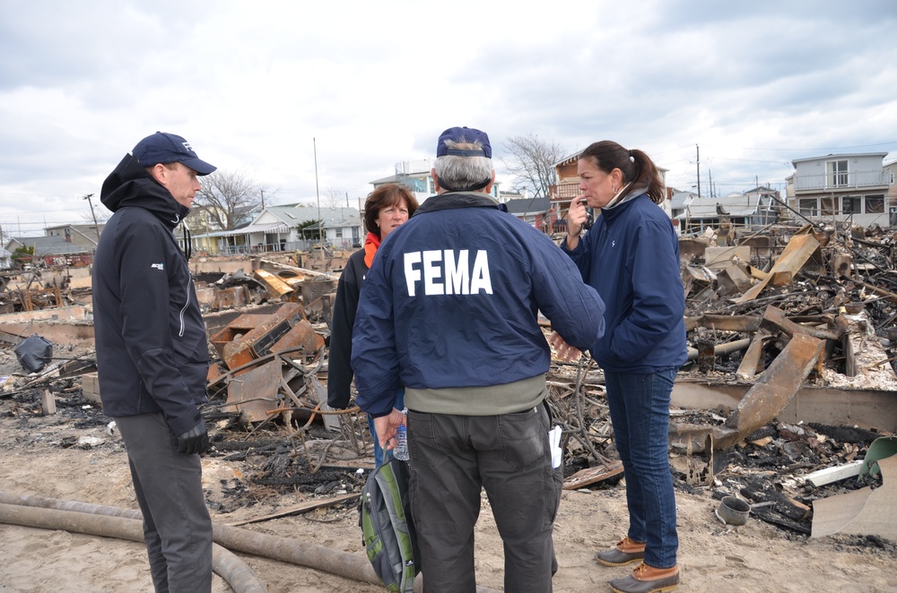 Residents of homes that burned during sub-tropical storm Sandy receive advice from FEMA community relations workers