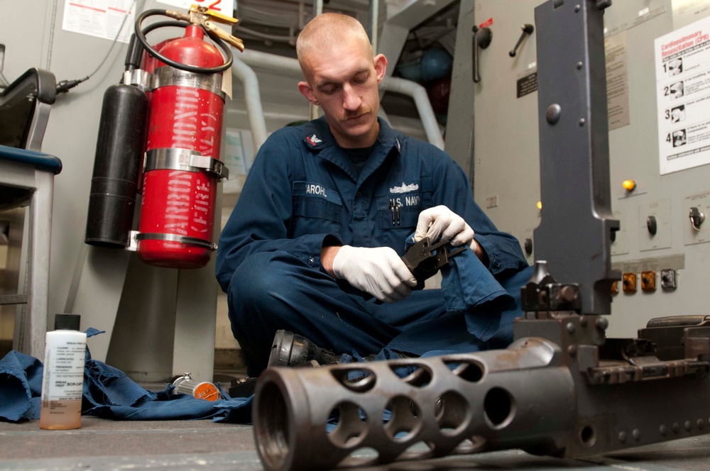 USS Hue City sailor cleans gun