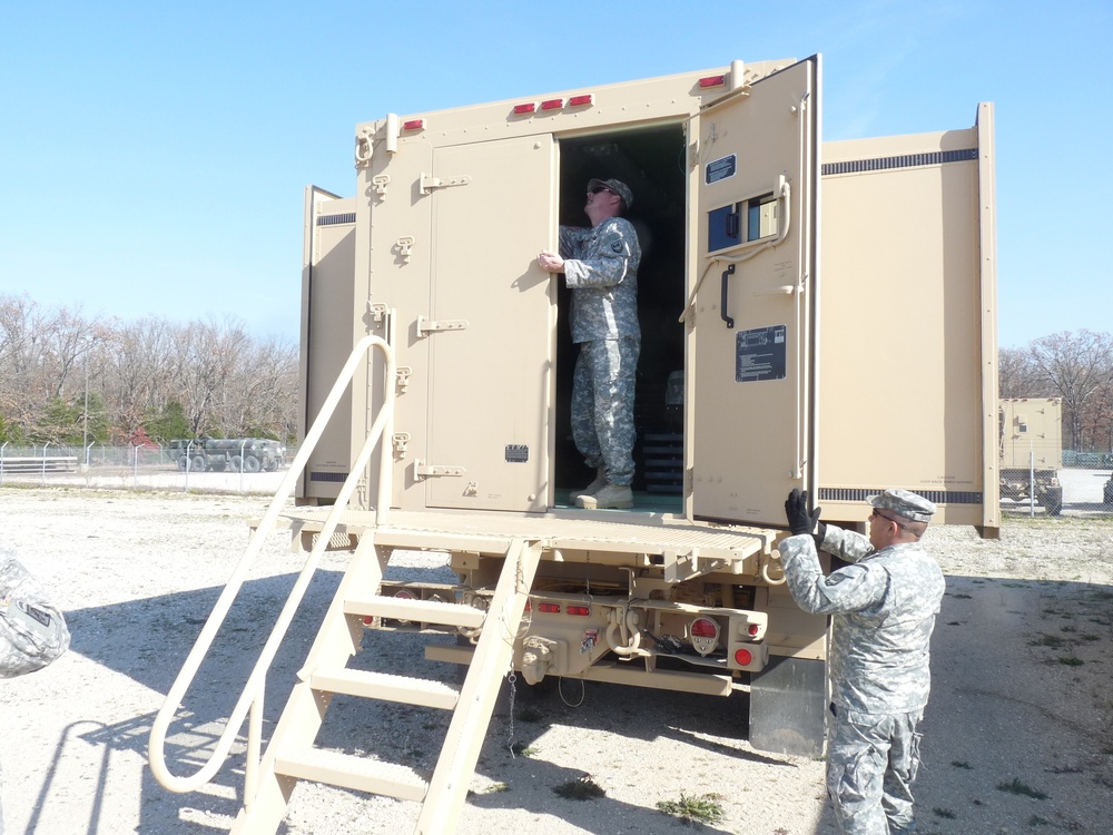 Soldiers prepare an M1087 medium tactical vehicle expansible van 