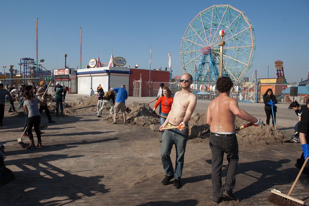 Volunteers lend a broom to Coney Island