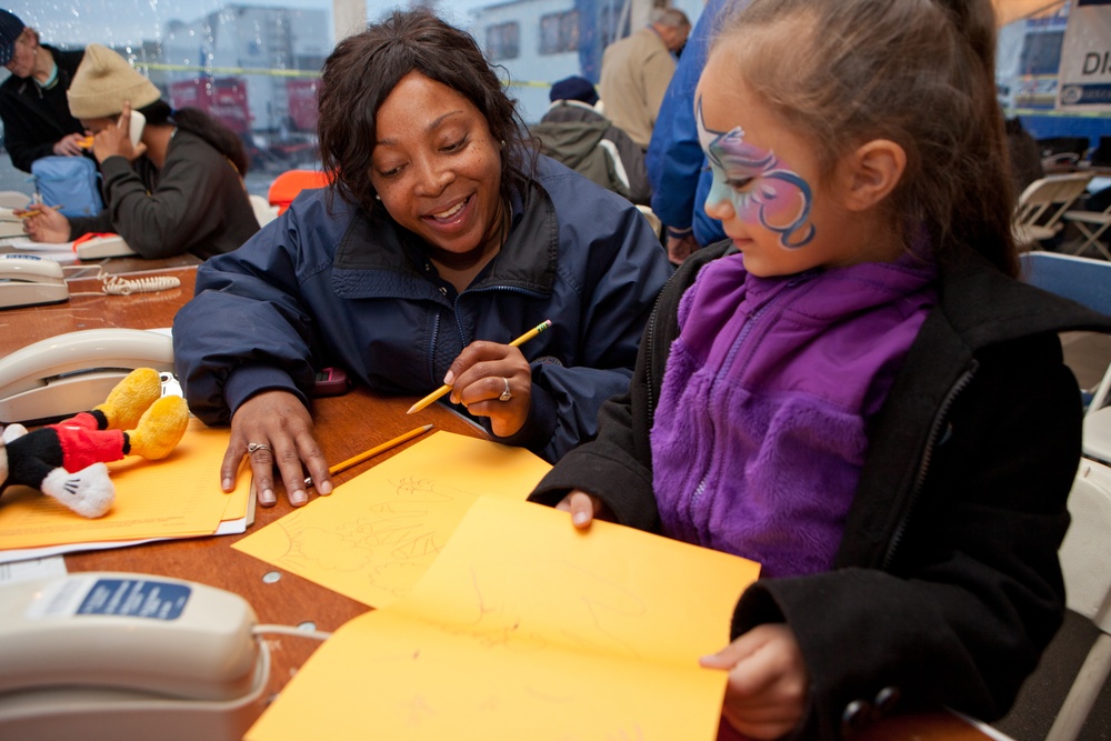 FEMA worker talks with young disaster survivor in a FEMA Disaster Recovery Center