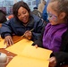 FEMA worker talks with young disaster survivor in a FEMA Disaster Recovery Center