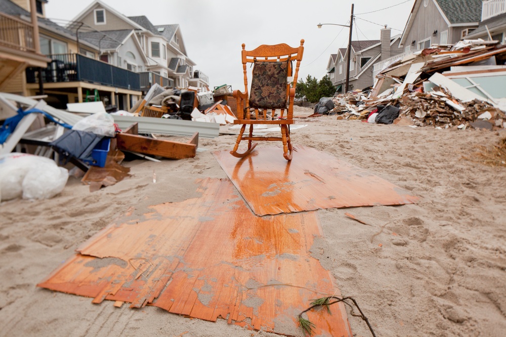 A rocking chair sits amidst debris piled up outside of homes in Long Beach, N.Y.