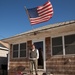 Hurricane Sandy survivor stands on the porch of his flooded home in Long Beach, NY