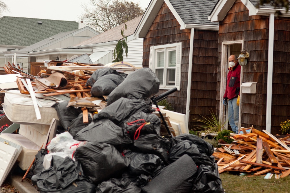 Hurricane Sandy survivor stands on the porch of his flooded home in Long Beach, NY