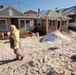 Hurricane Sandy survivor walks in front of her flooded home in Long Beach, NY