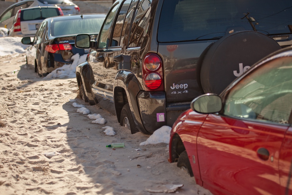 Cars stuck in sand in front of homes in Long Beach, New York