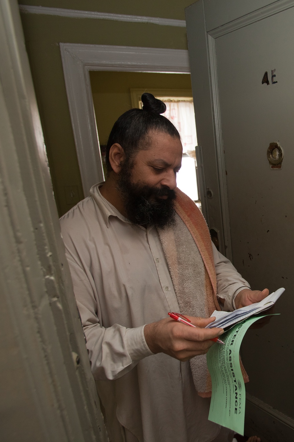 Hurricane survivor reads FEMA/state disaster assistance flyer