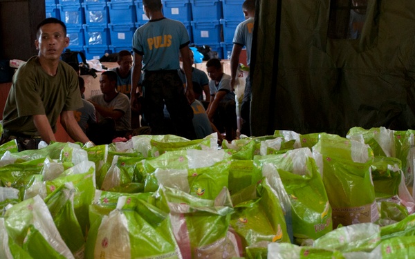 Philippine service members, U.S. Marines off-load supplies in Davao