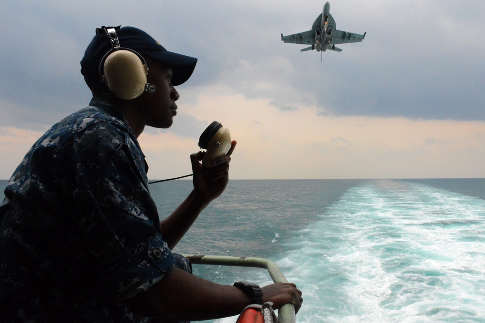 USS John C. Stennis sailor stands aft lookout watch