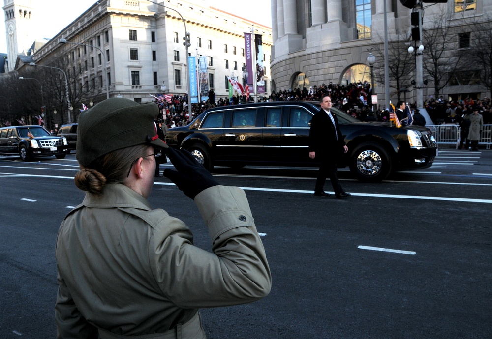 Young marine salutes President Obama as he waves to the crowd along Pennsylvania Avenue, Washington