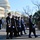Presidential Inaugural Parade A group of military personnel in formal dress uniforms are marching in formation on a street in front of the United States Capitol building in Washington, D.C. The scene appears to be an official ceremonial event, likely an inaugural parade or state funeral procession, given the formal attire and organized formation. The image was taken during winter, evidenced by bare trees and clear cold-weather conditions.